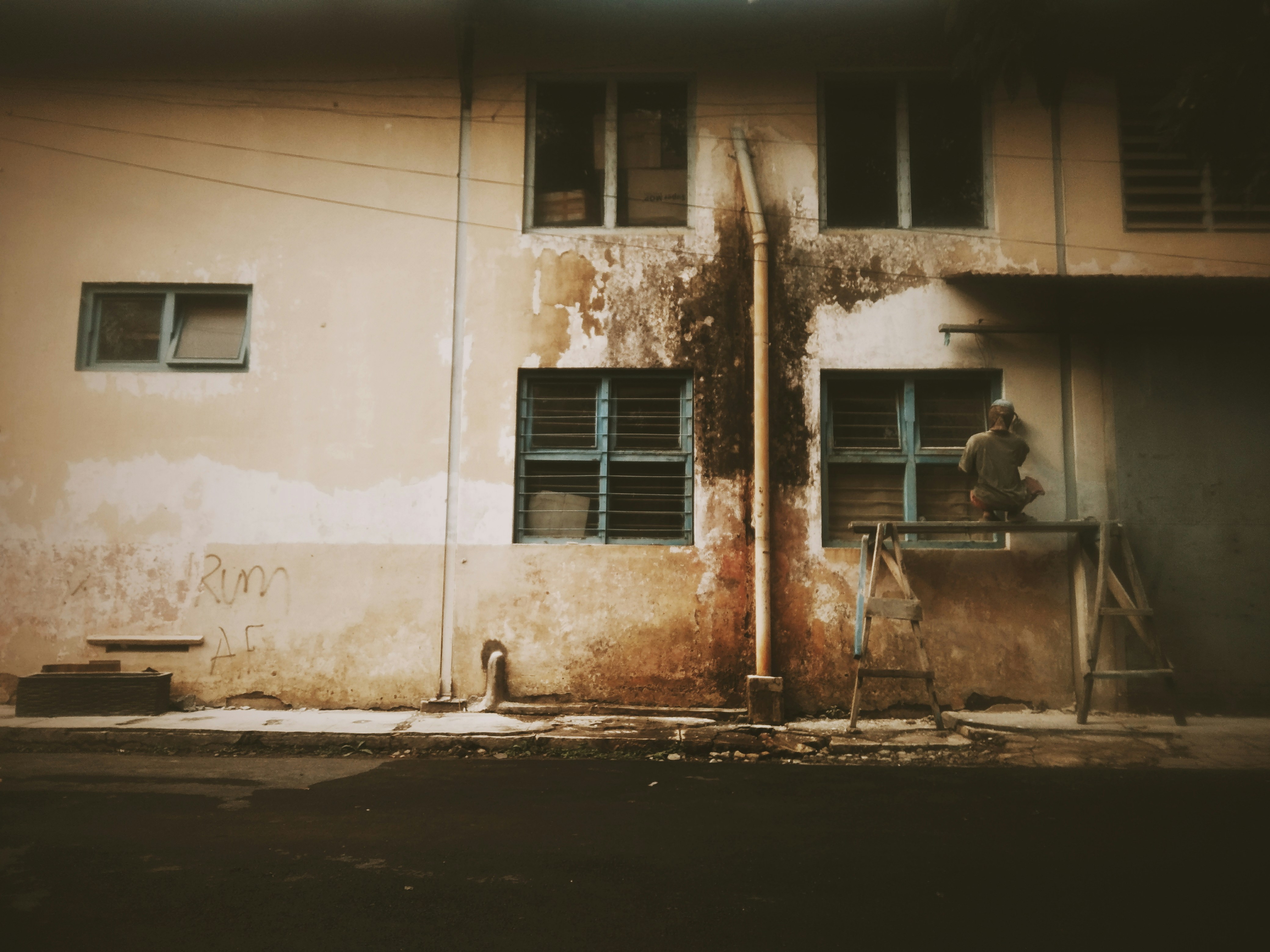 Technician inspecting moisture damage on a building facade