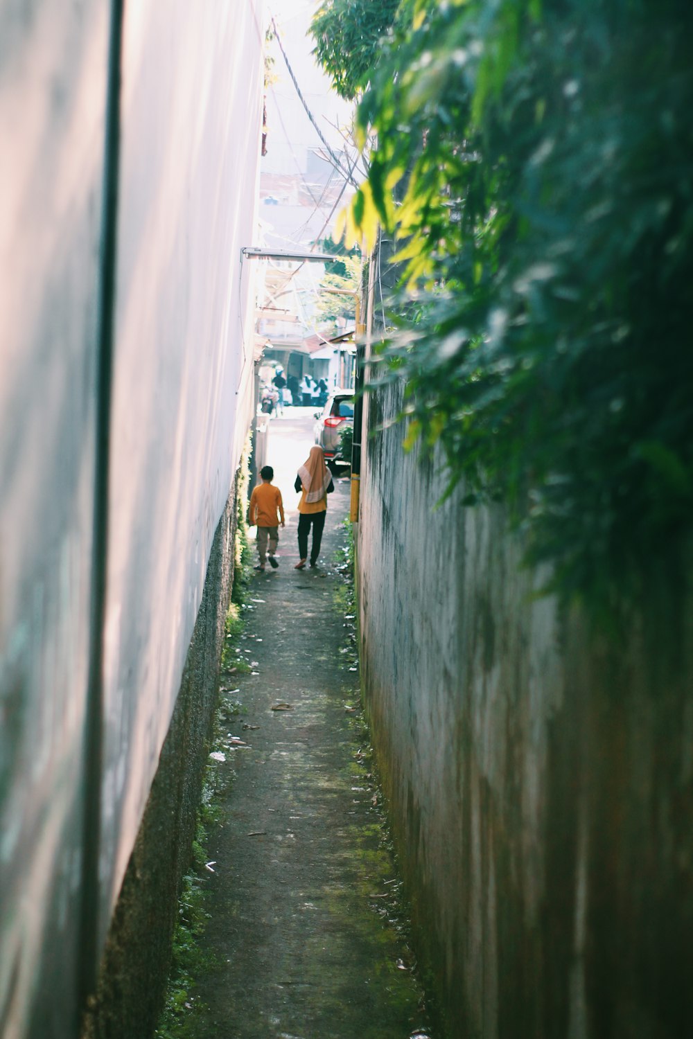 people walking down a narrow street