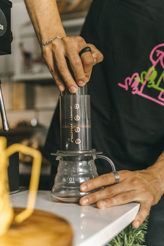 a person using an AeroPress KopiFeed.id