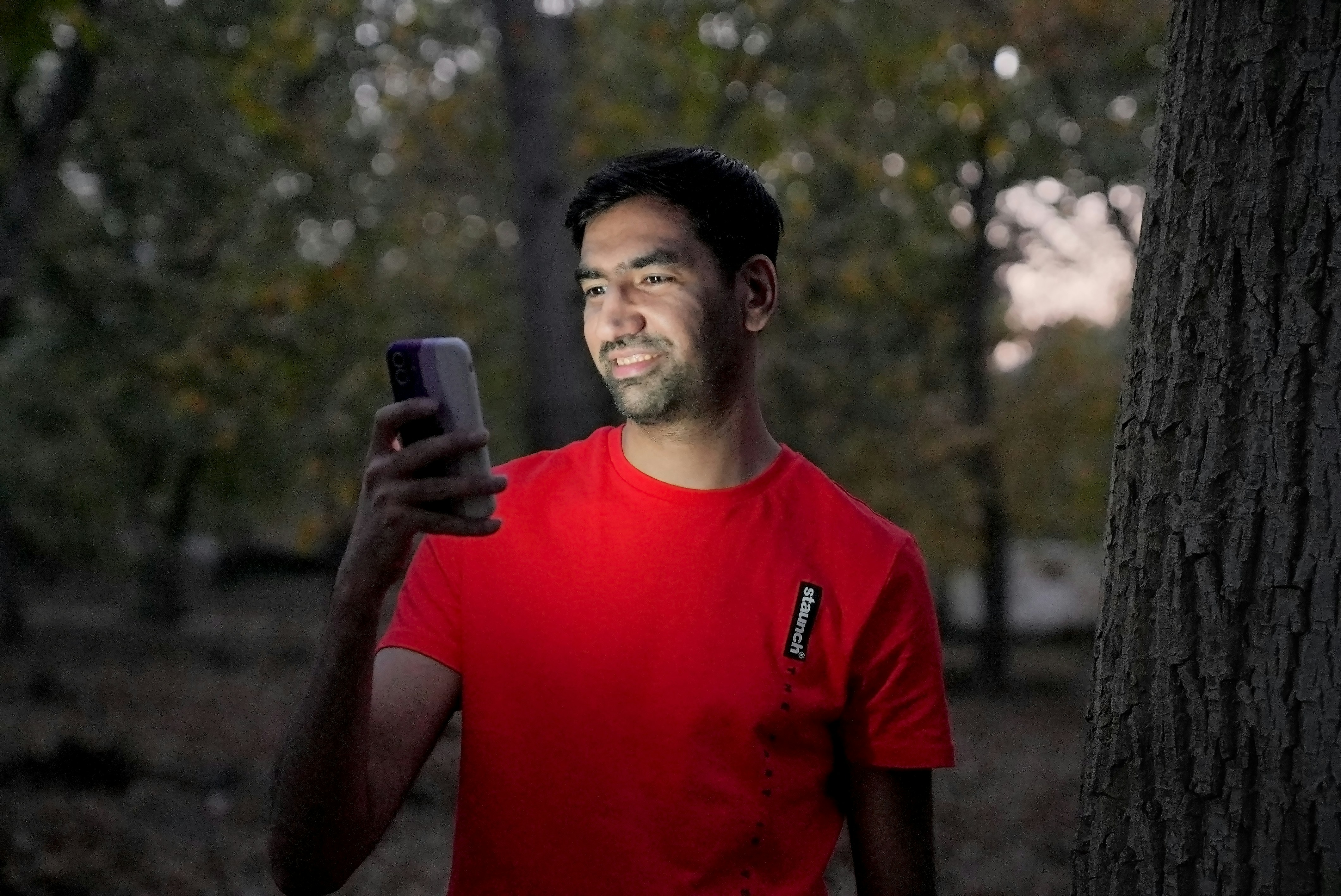 View of attractive boy in the dark working on the phone