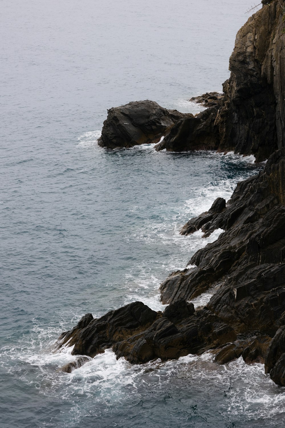 a rocky shoreline with waves crashing against it
