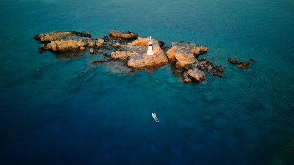 A rocky islet with a small lighthouse in turquoise water off Datça