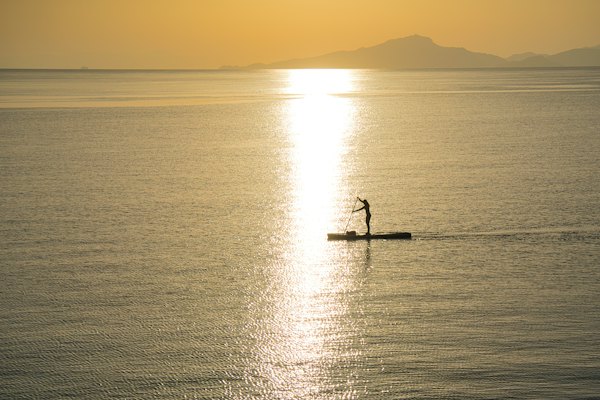 A paddleboarder on a still sea at sunset off the Datça peninsula