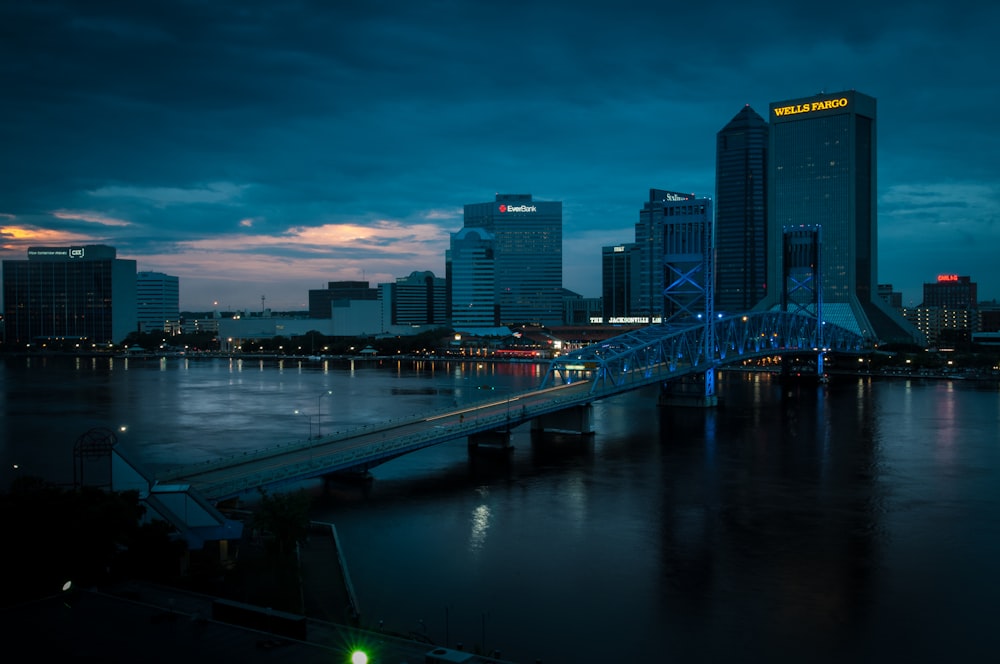 a bridge over a river with a city in the background