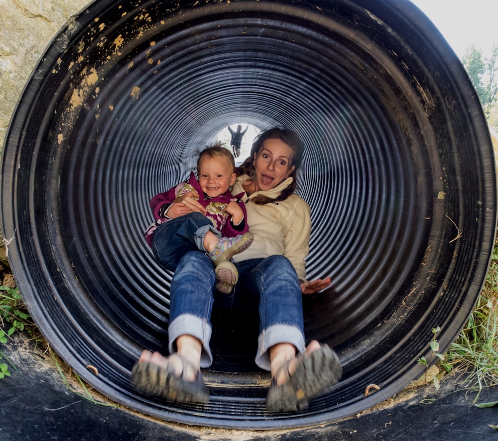 a person and a baby in a tire