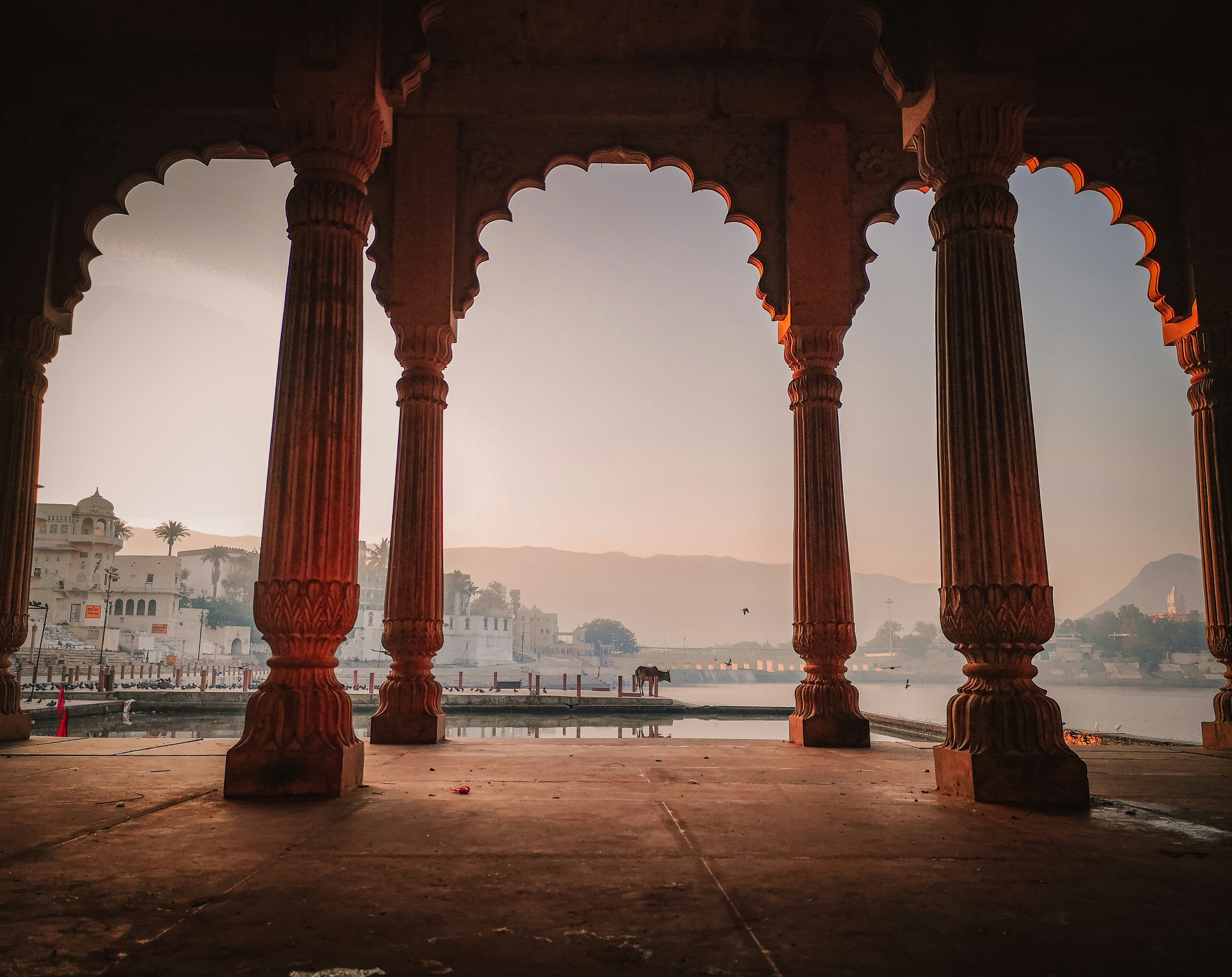 a group of large pillars in front of a body of water