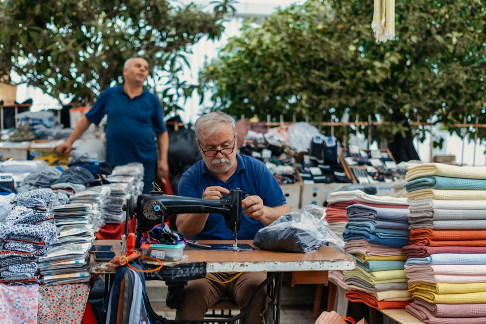 a man sitting at a table with a gun and a pile of laundry