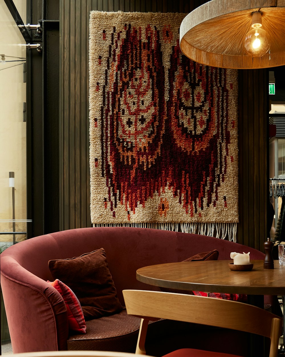 a red couch in front of a table with a red curtain