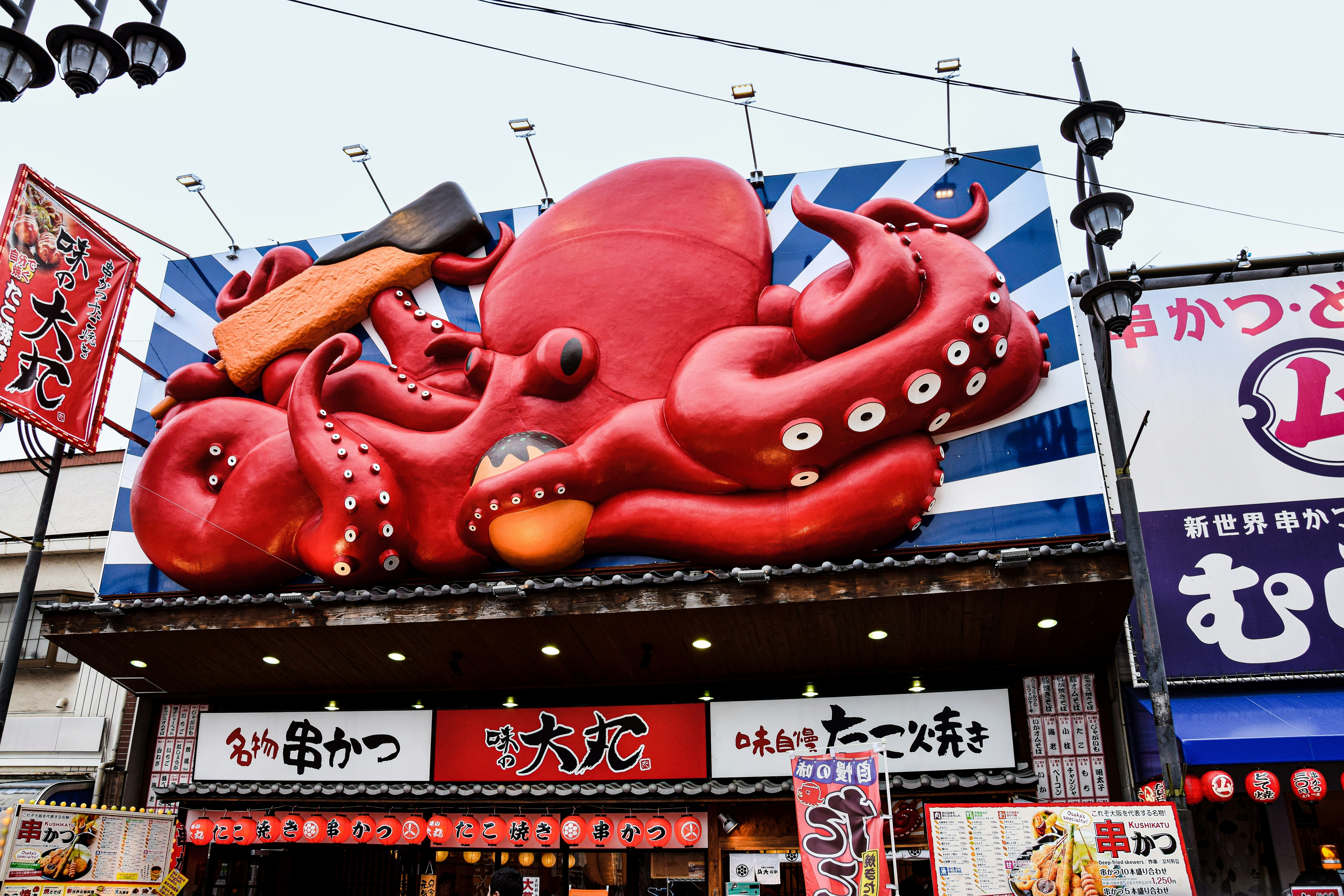 a large red fish statue on a building, Osaka, Japan-