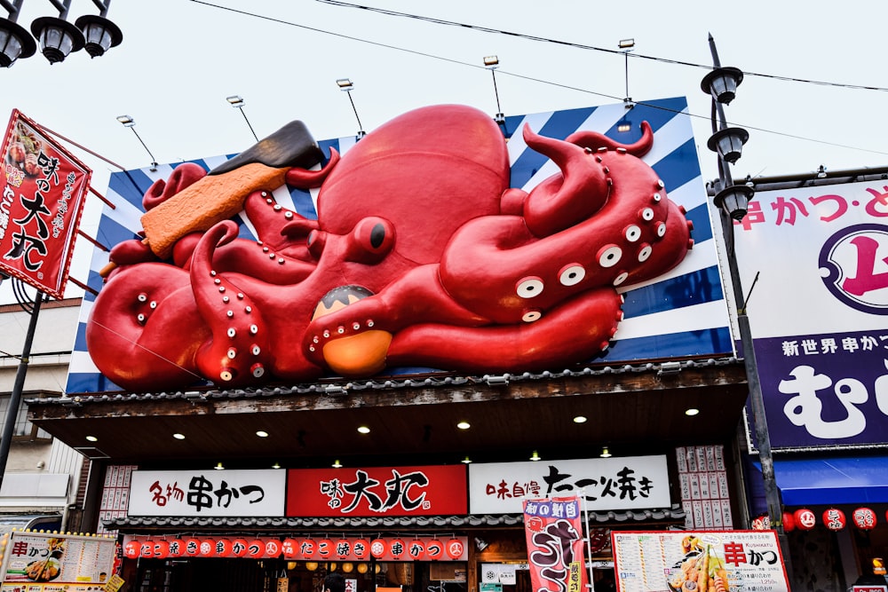 a large red fish statue on a building