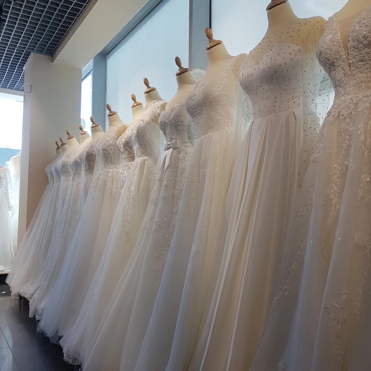 Robes de mariée alignées en atelier