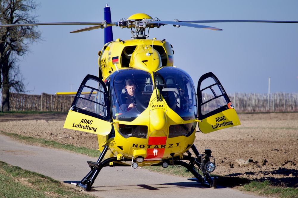 a person driving a yellow helicopter