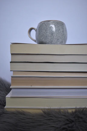 A stack of the author’s books arranged artistically with soft lighting and a cup of tea nearby.
