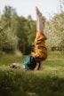 a person doing a handstand in a grassy area