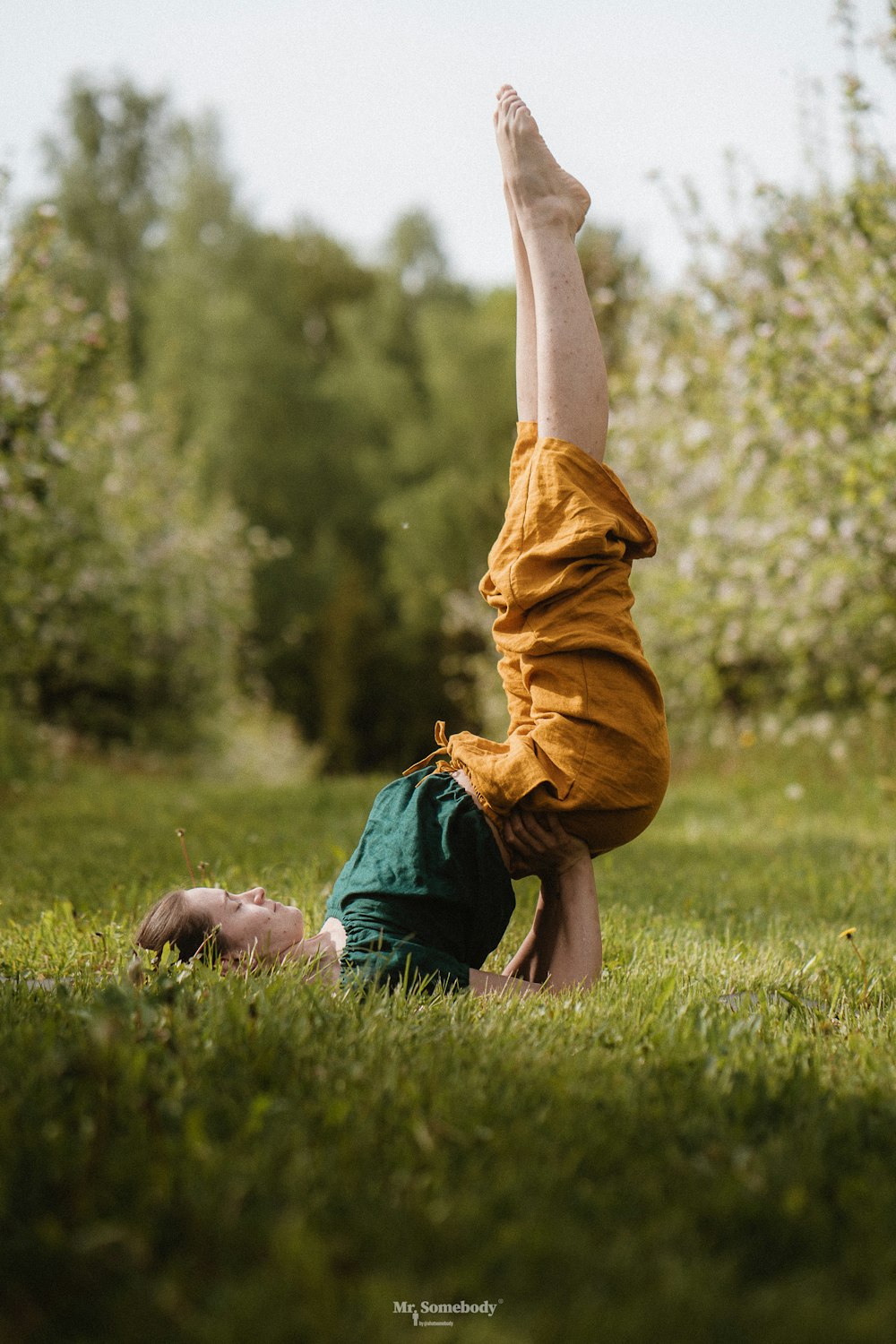 a person doing a handstand in a grassy area