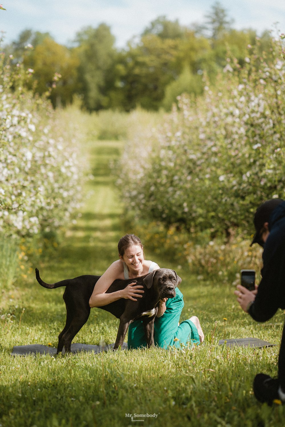 a man and a woman with a dog in a park