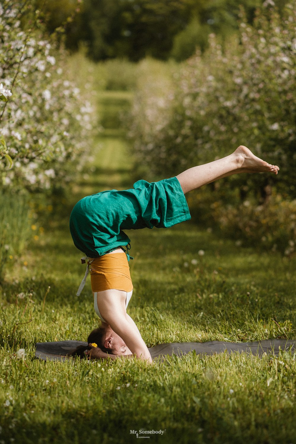a person doing a handstand in the grass