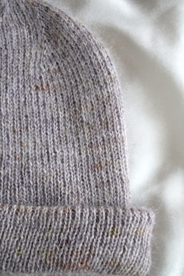 Close-up of knitted scarves and hats in soft, natural fibers reflecting lookorye’s quality craftsmanship.