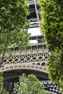 Close-up of intricate steelwork on a walkway railing, highlighting craftsmanship against a backdrop of lush greenery.