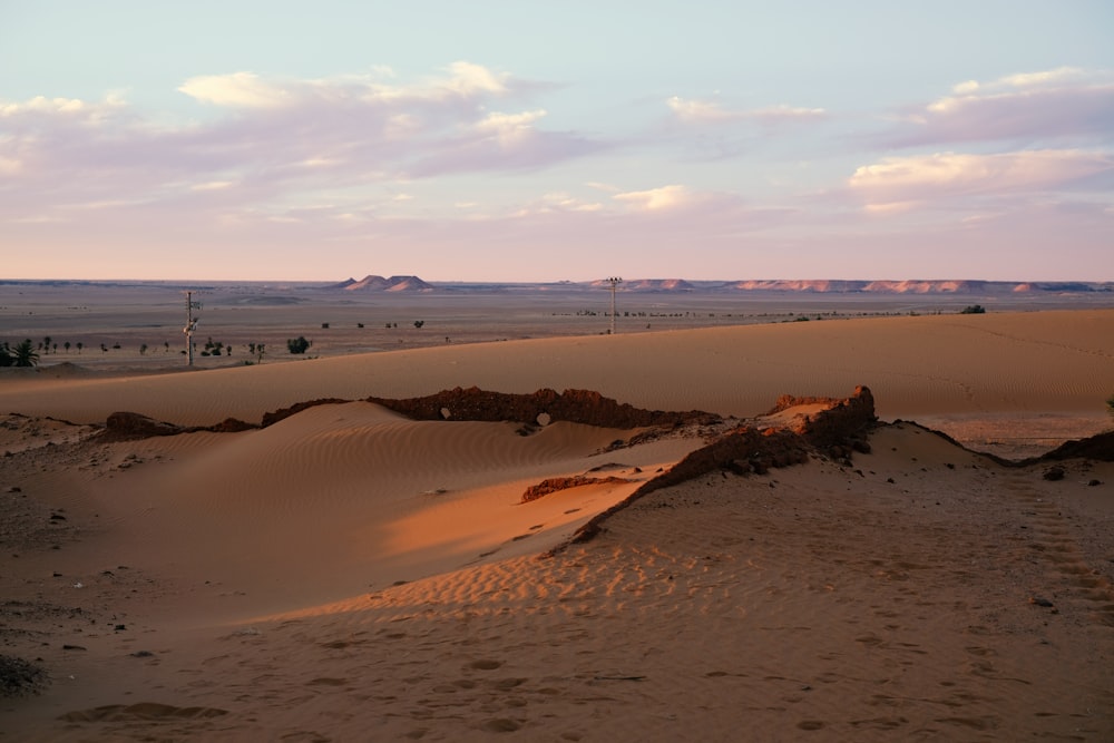 a sandy beach with a body of water in the background