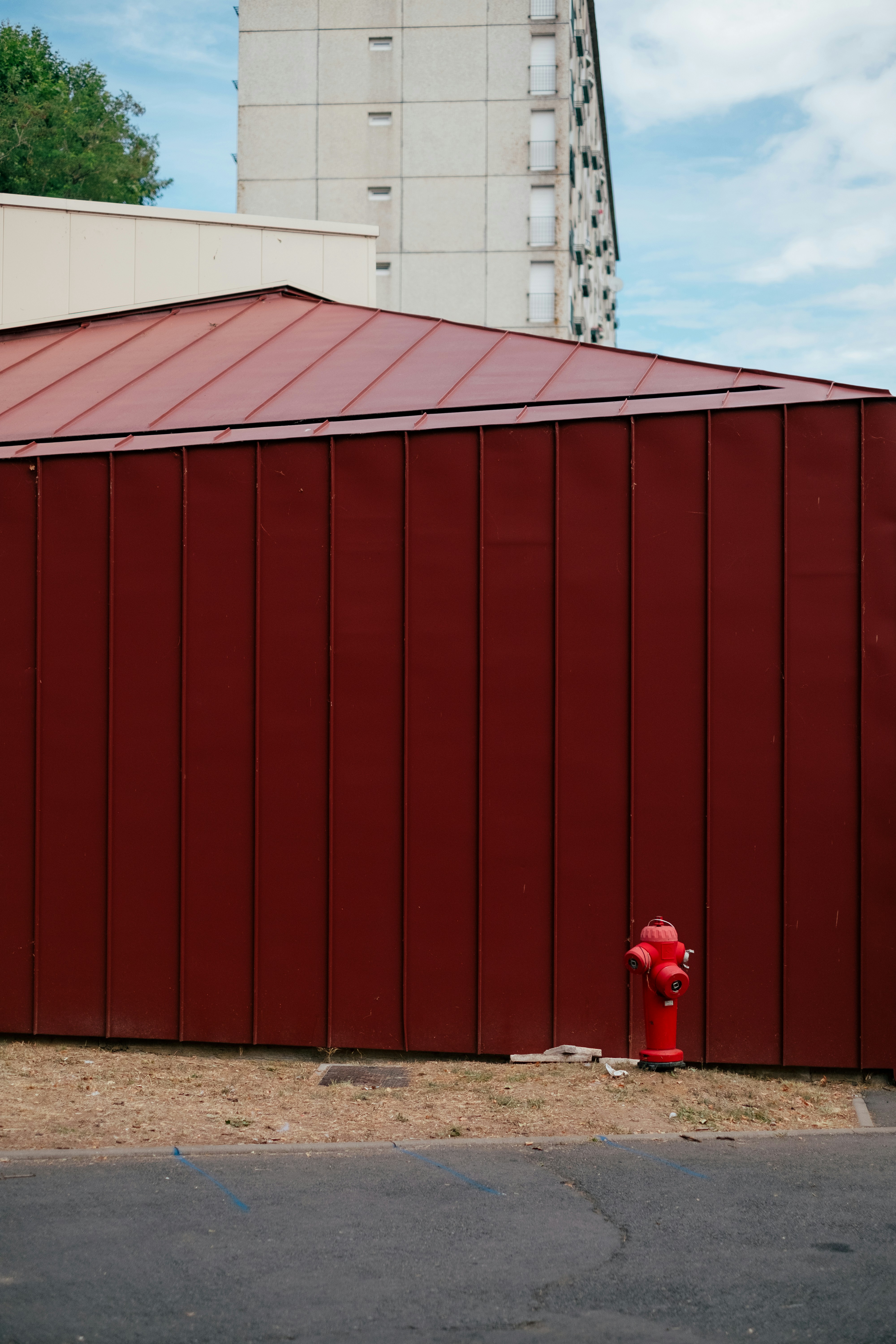 a red fire hydrant next to a large red building