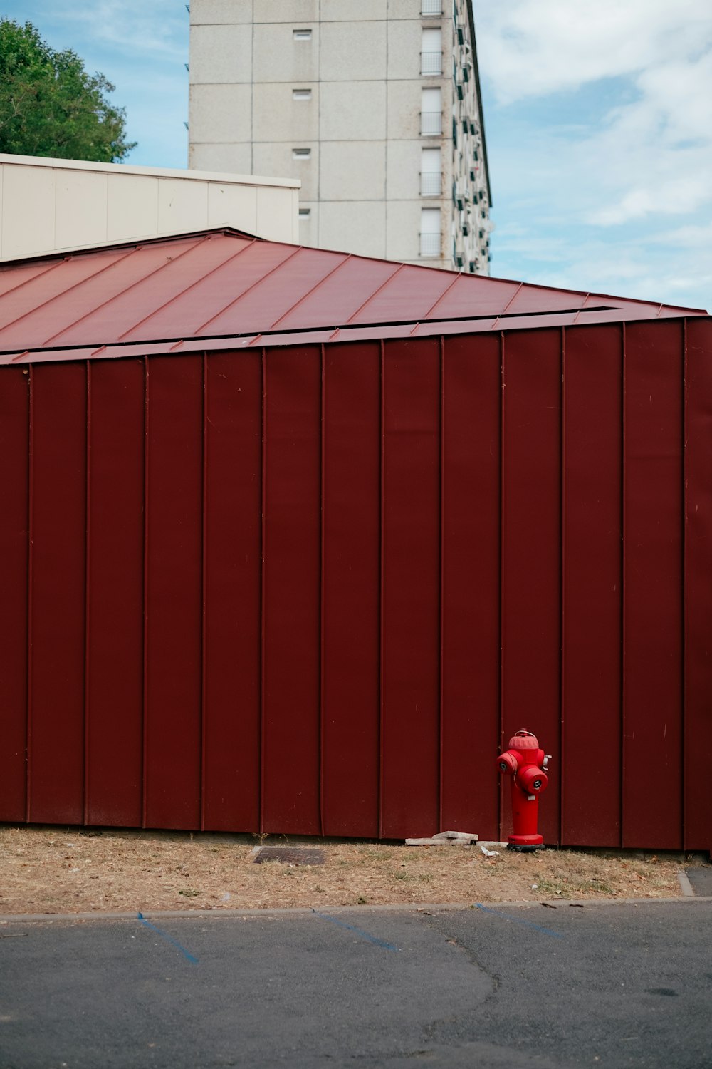 Una boca de incendios roja junto a un gran edificio rojo