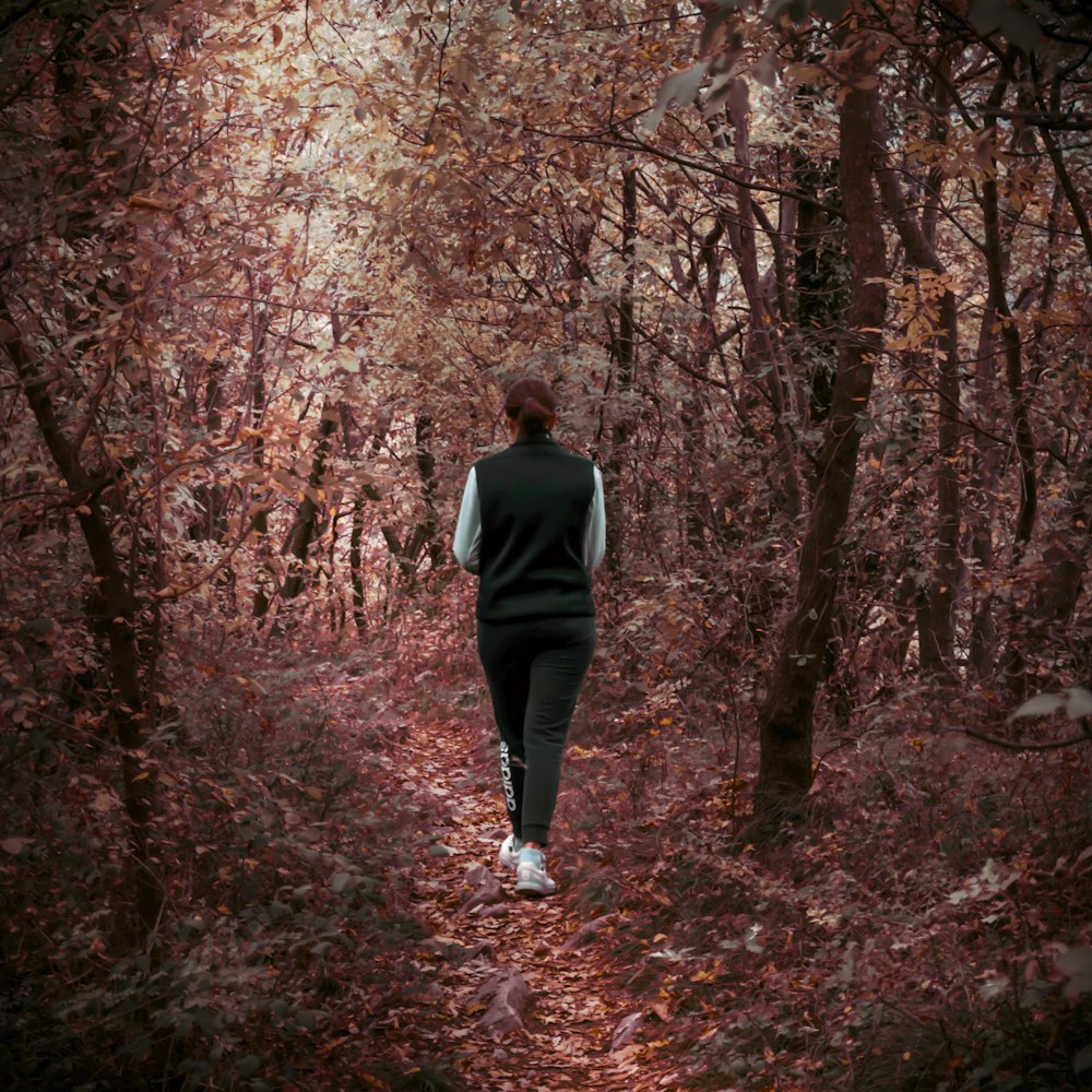 a person walking on a path surrounded by trees