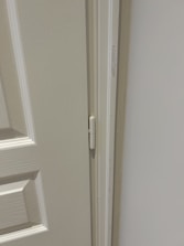 Close-up of a technician performing maintenance on a commercial door mechanism.