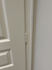 Close-up of a professional installing a wooden door frame in a modern interior.