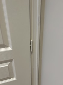 Close-up of a technician performing maintenance on a commercial door mechanism.