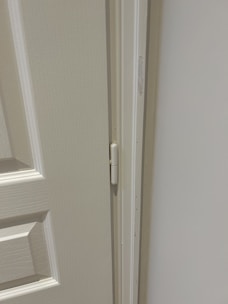Close-up of a professional installing a wooden door frame in a modern interior.