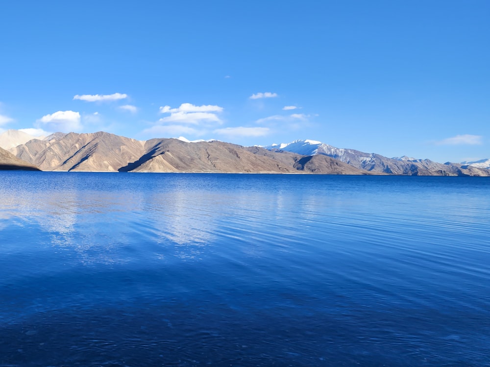 a body of water with mountains in the background