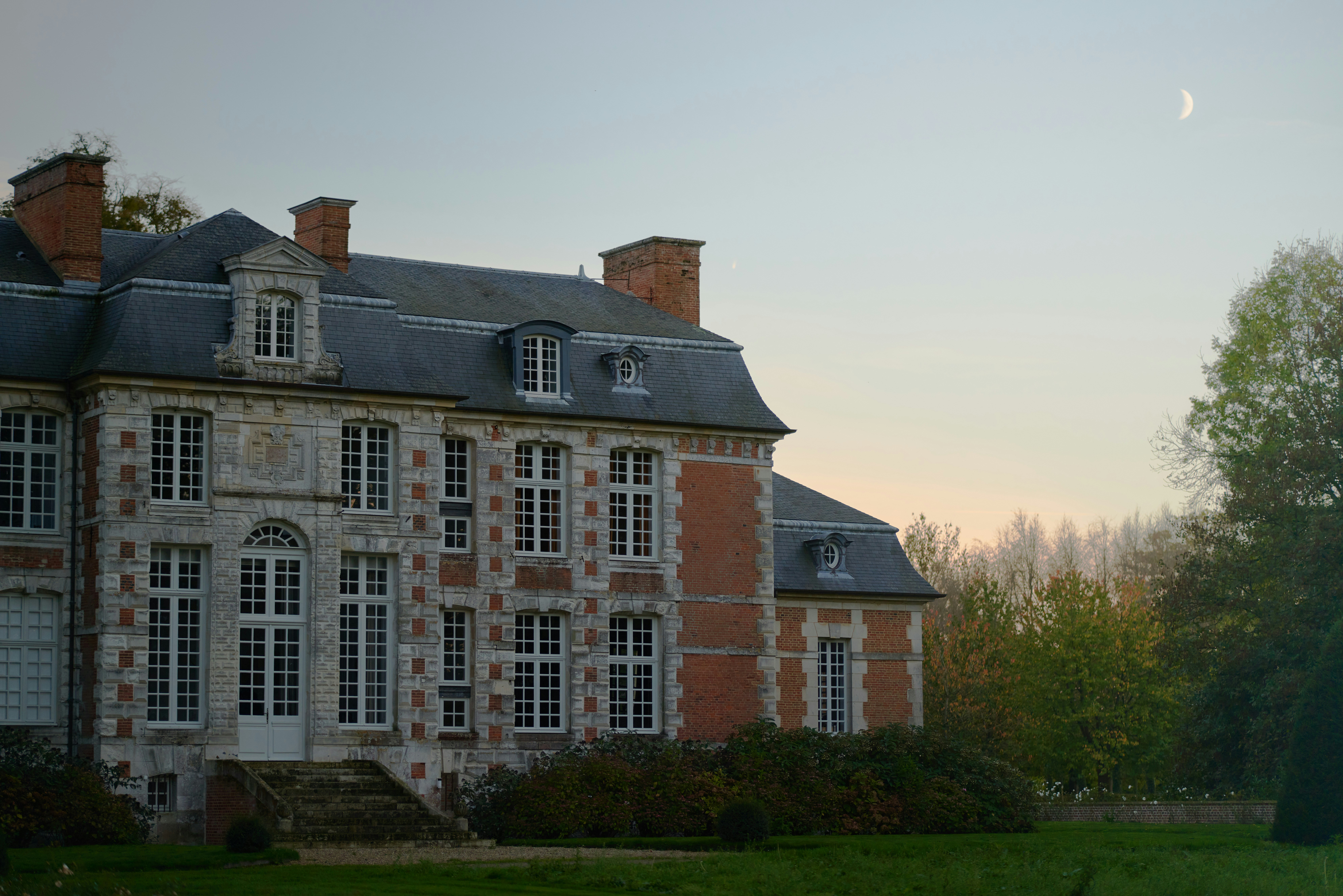 a large brick building with a lawn in front of it