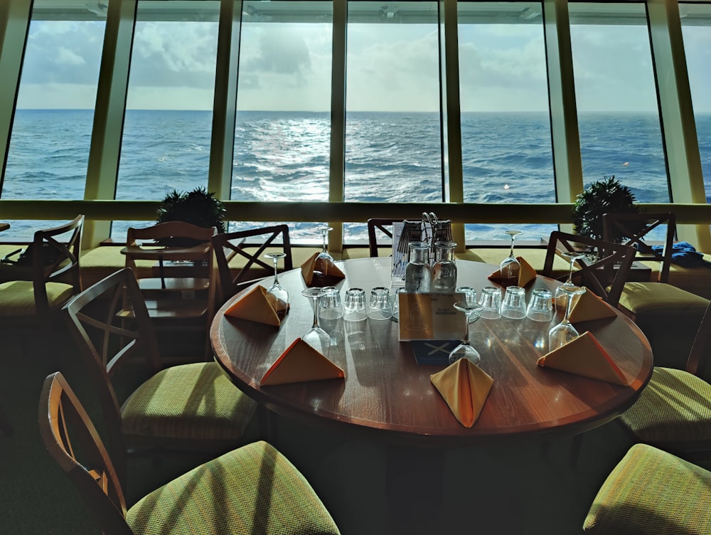 a table with glasses and bottles on it by a window with water