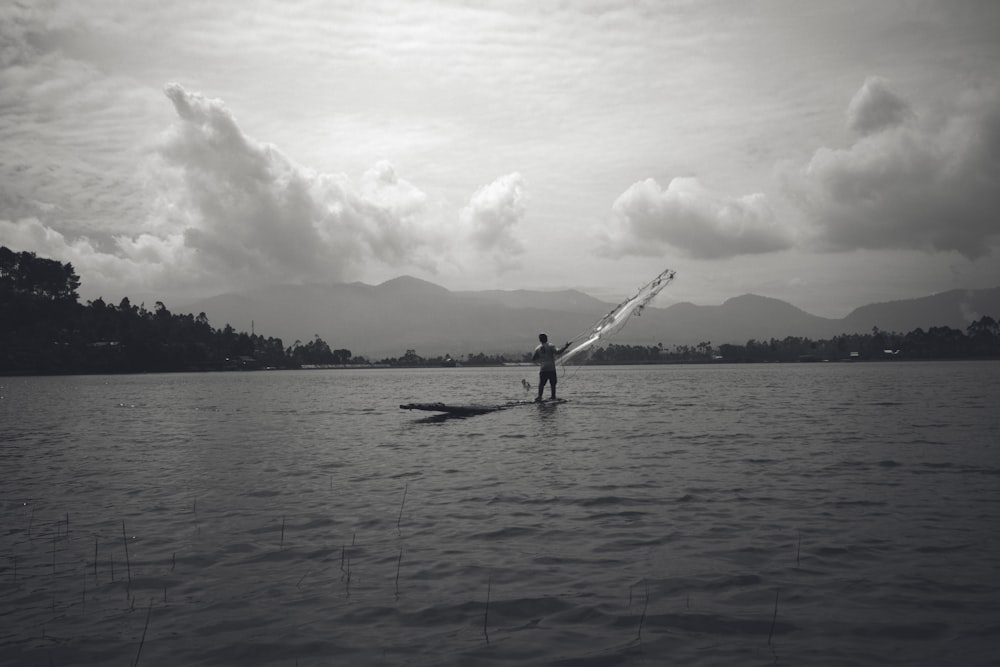 a person standing on a boat in a lake