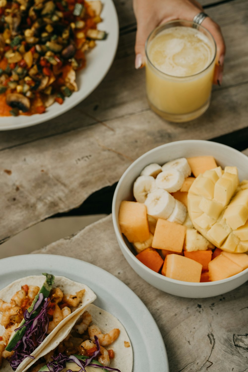 a table with plates of food and a glass of juice