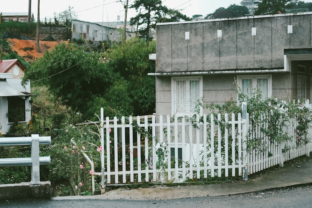 uma cerca branca piquete na frente de uma casa