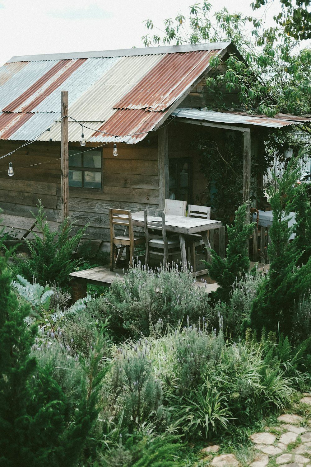 a wooden house with a table and chairs in the front