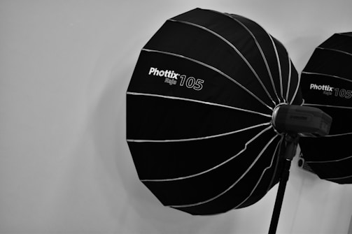 Two large black photography softboxes with the brand name 'Phottix 105' are mounted on stands against a plain background. Each softbox is paired with a flash unit, ready for use in a studio setting.
