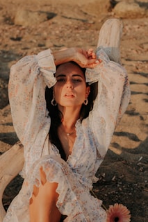 A close-up of a flowy skirt with floral patterns, resting on a sandy beach.