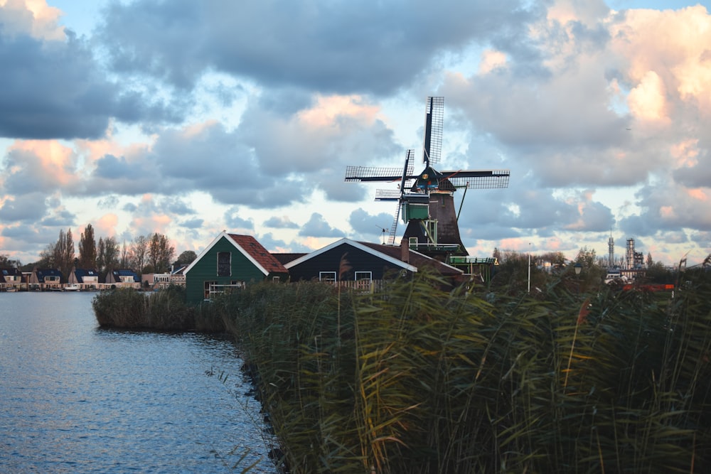 un moulin à vent à côté d’un plan d’eau