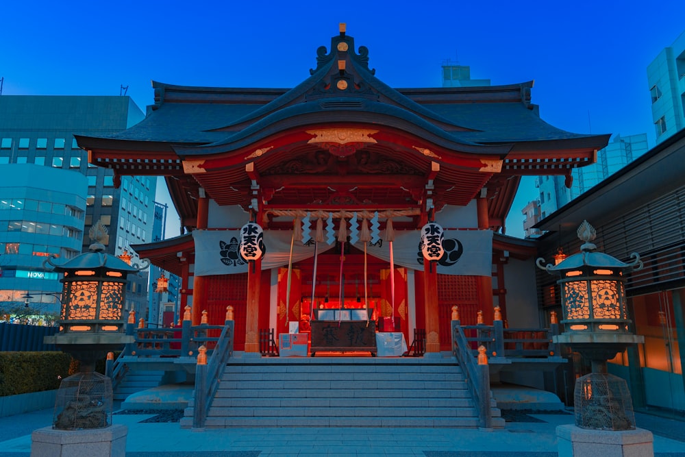 a red asian building with a black roof and a staircase