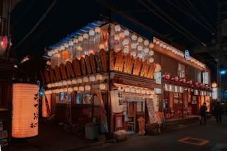 A vibrant street scene in Japan showcasing traditional lanterns and modern buildings under a clear sky.