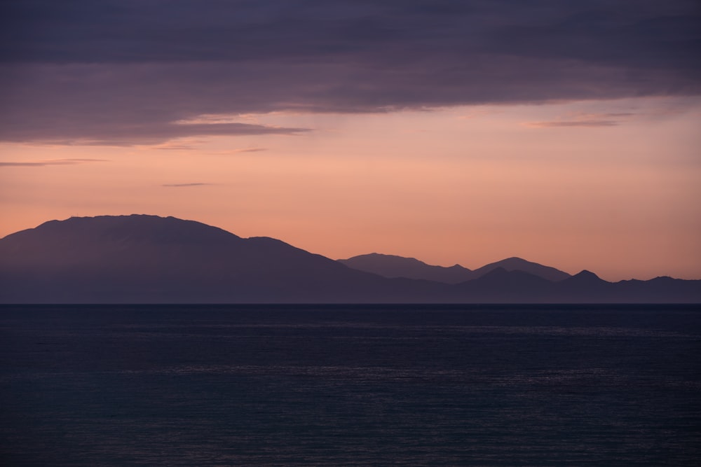 a body of water with mountains in the background