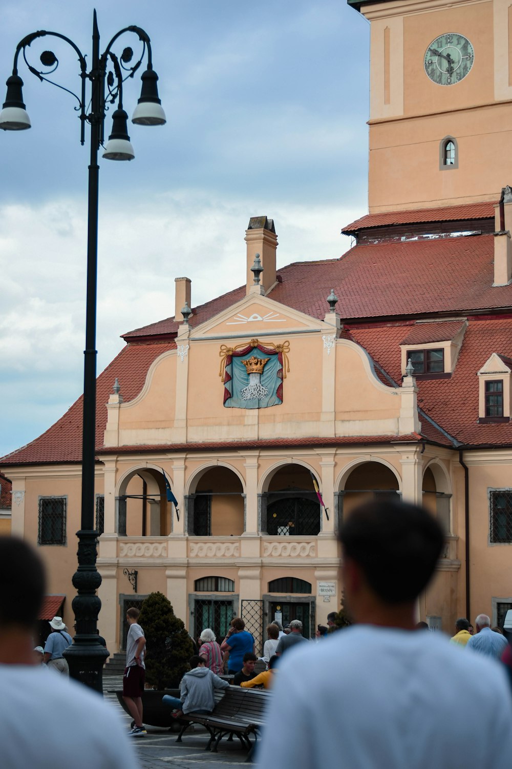 a group of people walking by a building with a clock on it