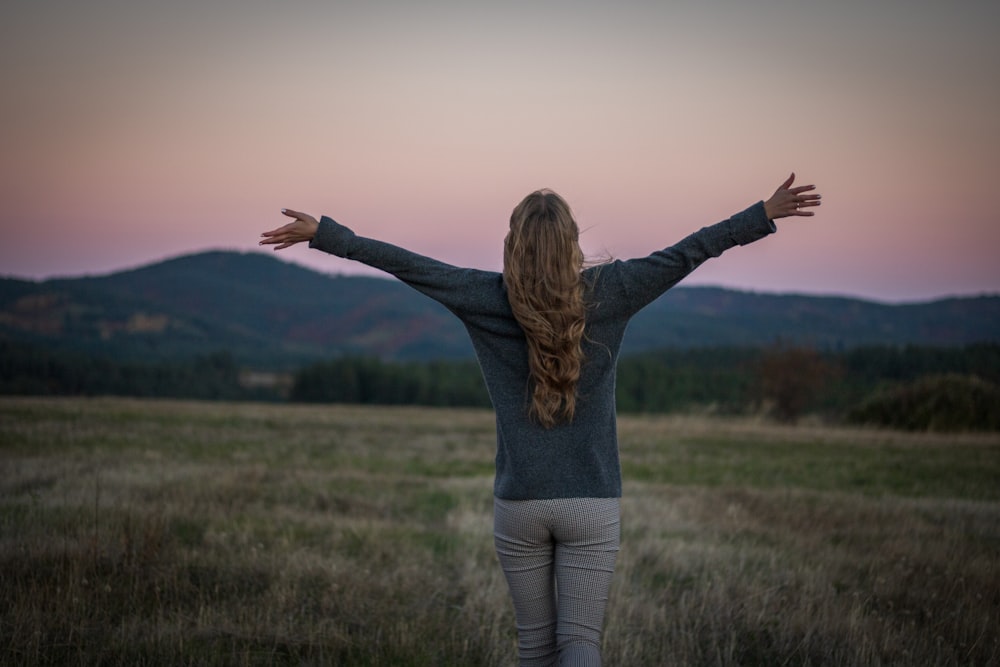 a person with the arms raised in a field