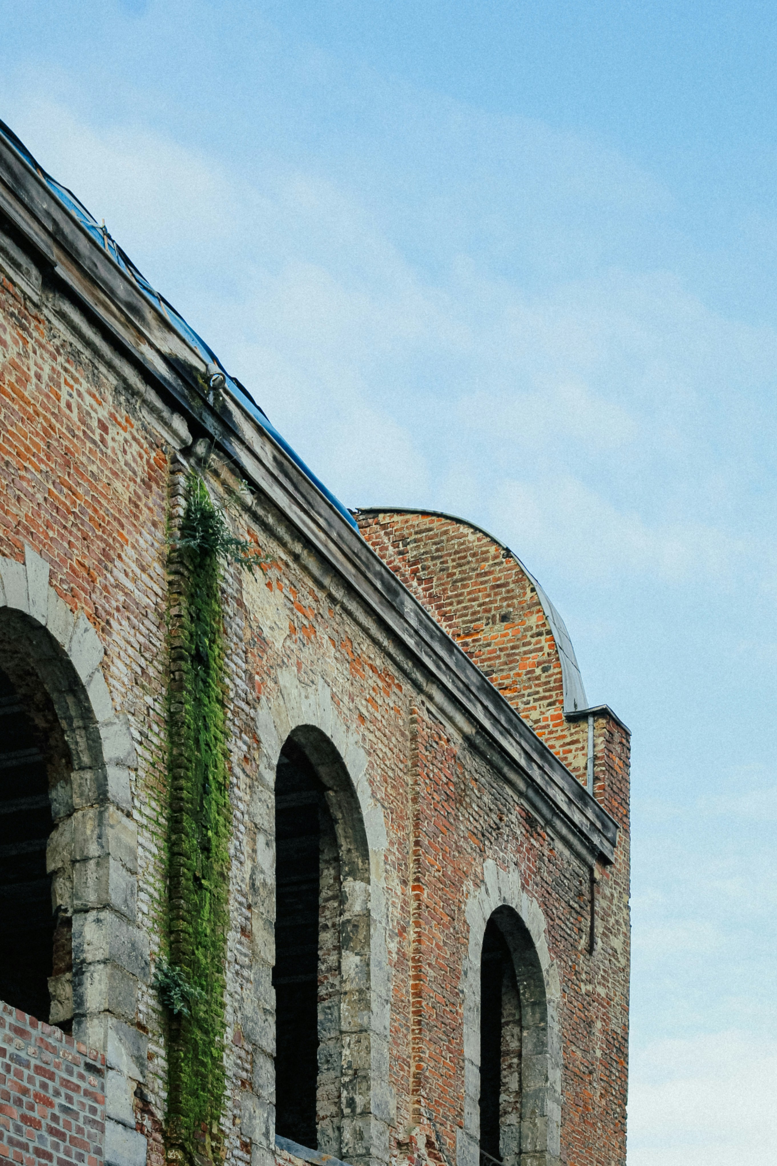 a brick building with a green roof