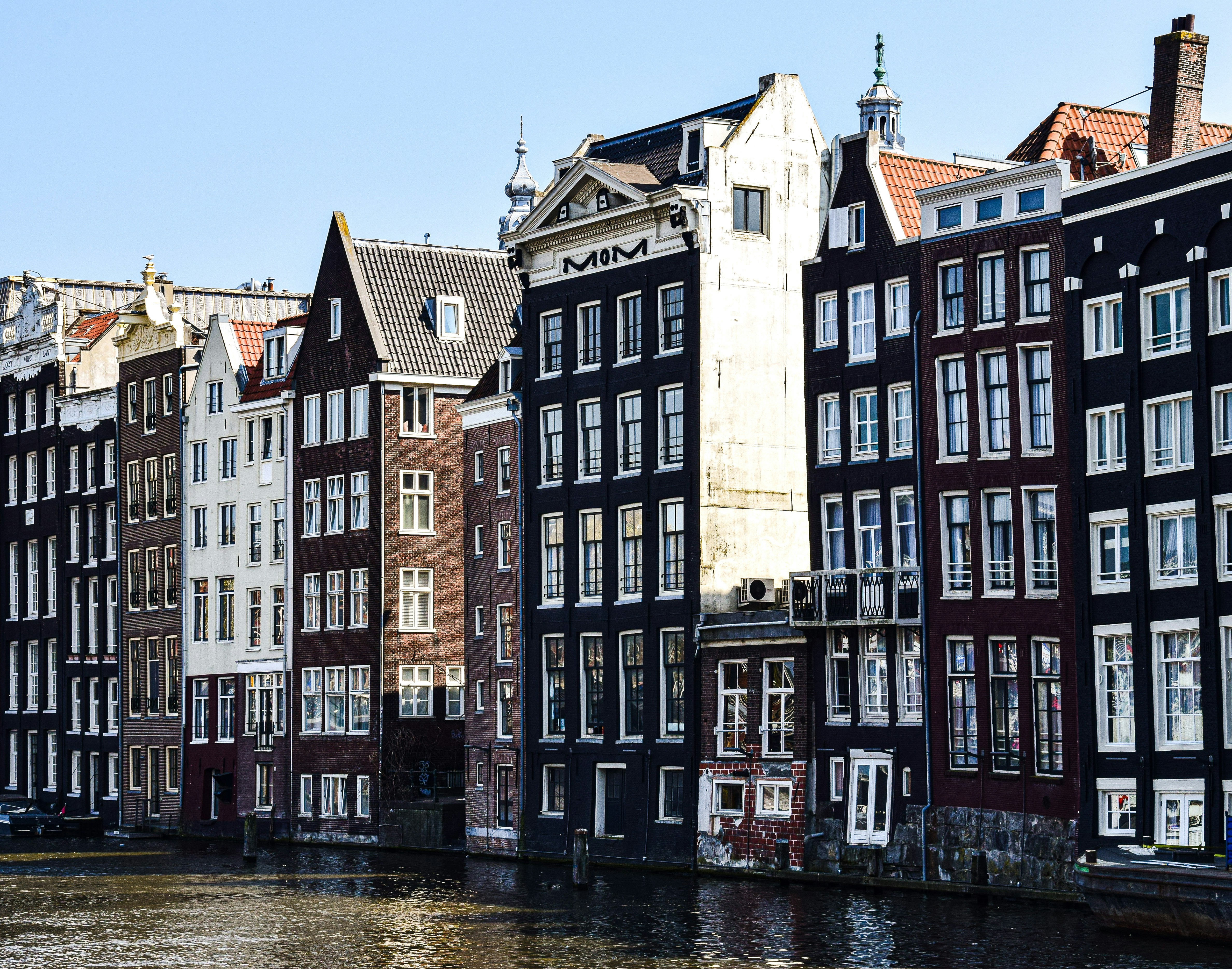 a row of buildings next to a body of water, Amsterdam, Netherlands.