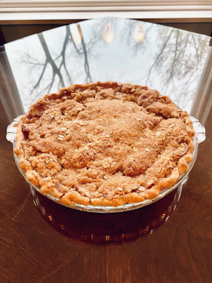 Freshly baked sweet potato pie cooling on a windowsill with sunlight streaming in.