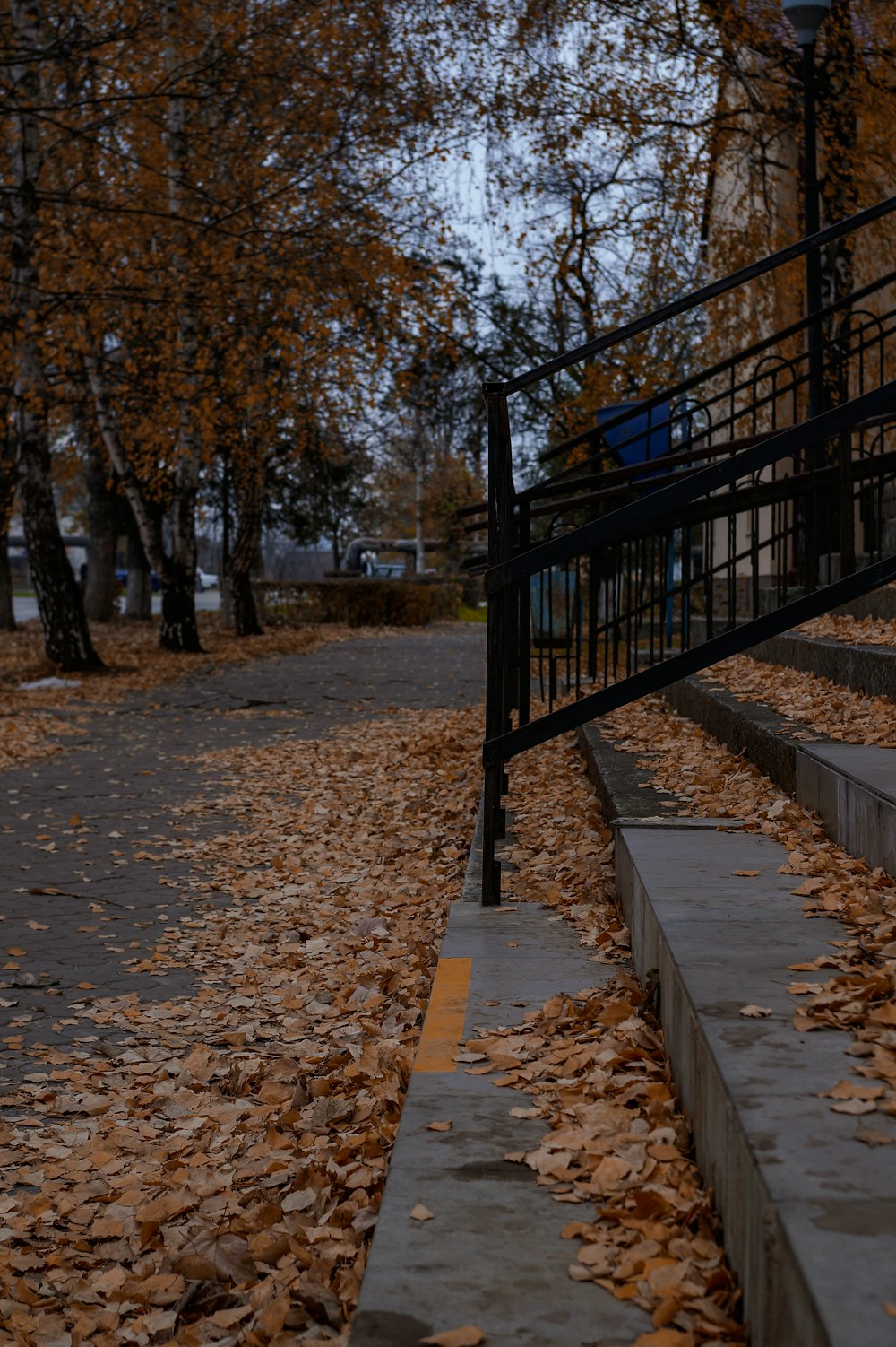 a black metal railing with trees on the side